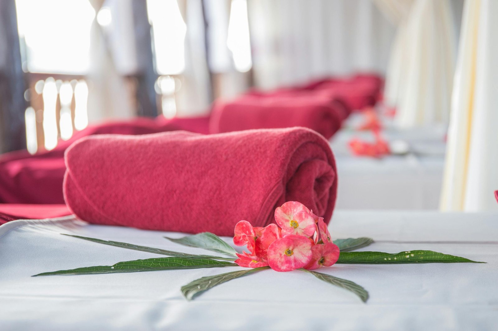 Elegant spa interior featuring red rolled towels and vibrant flowers, perfect for relaxation.
